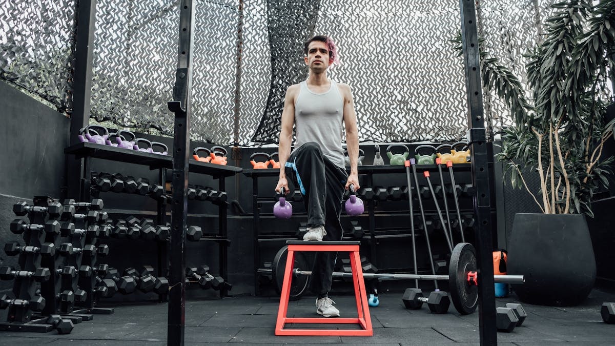 Adult male performing kettlebell exercises in a modern Mexico City gym.